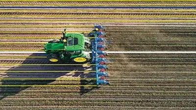 Traktor mit Pflug auf dem Feld, Vogelperspektive