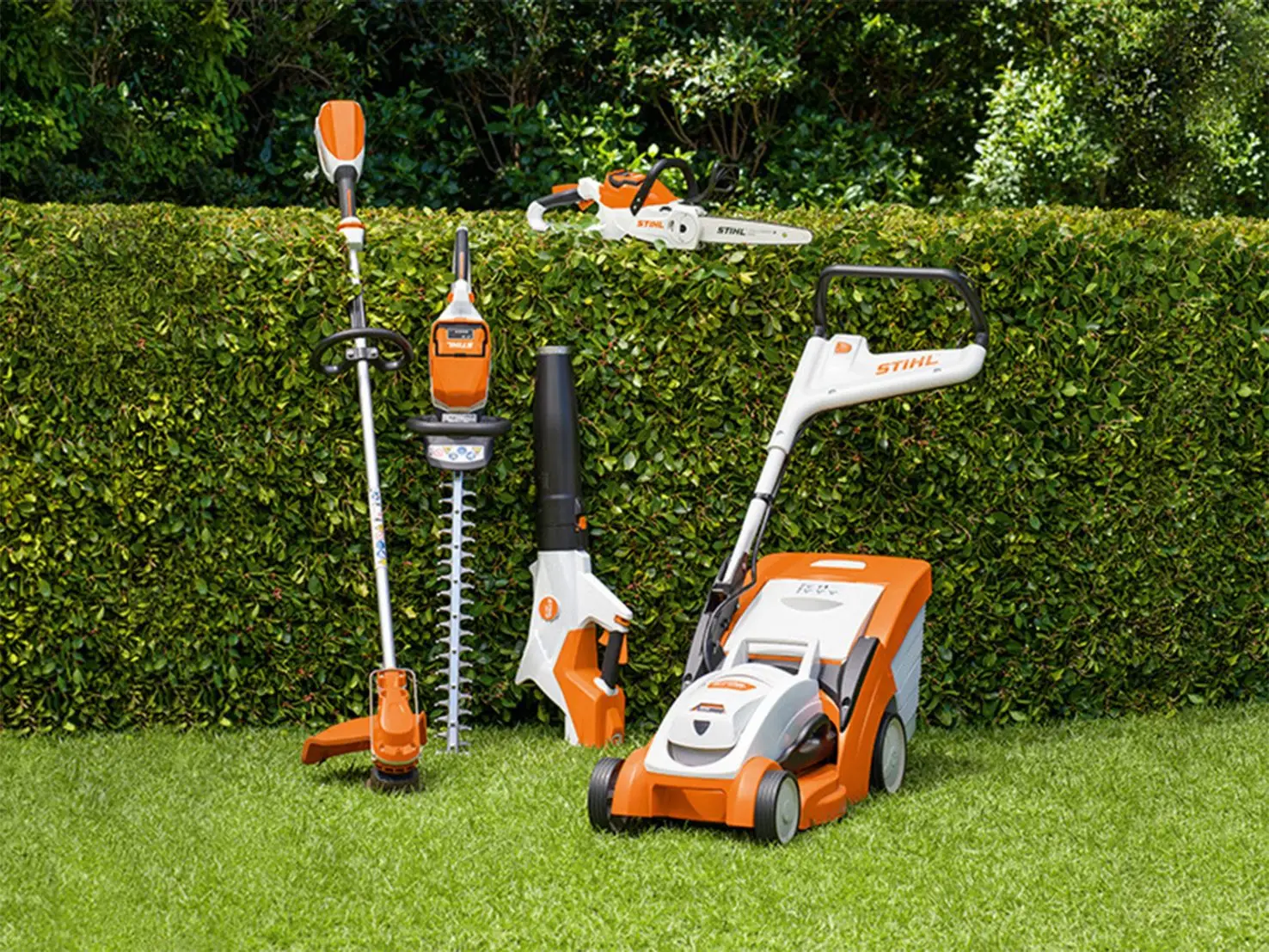 Stihl Maschinen lehnen an einer Hecke